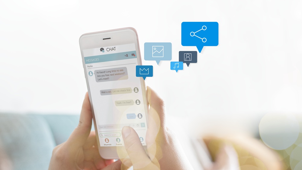 Mulher trocando mensagens no celular e ícones extrapolando a tela do aparelho.